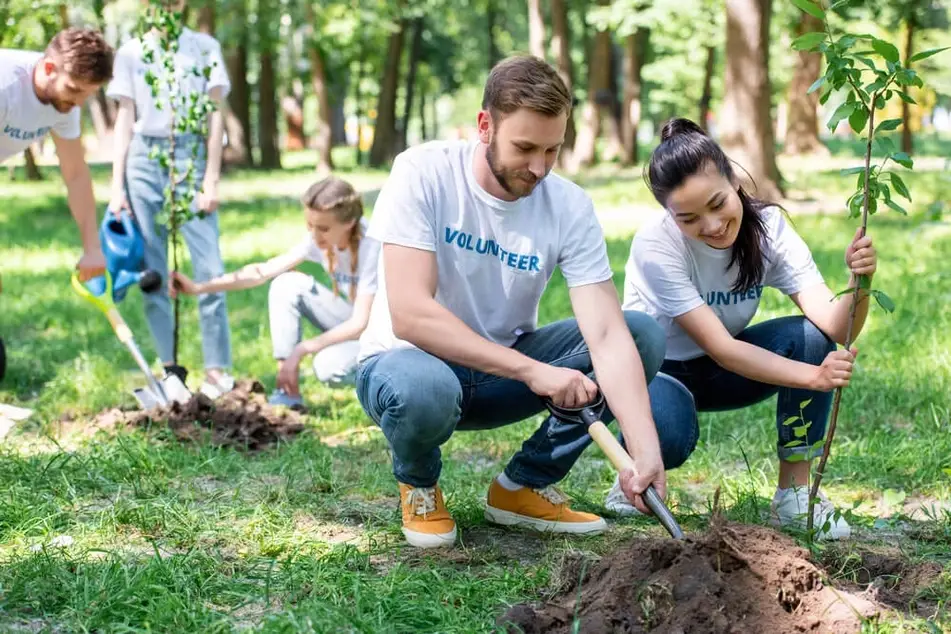 Volunteers at an environmental volunteer opportunity laugh and smile
