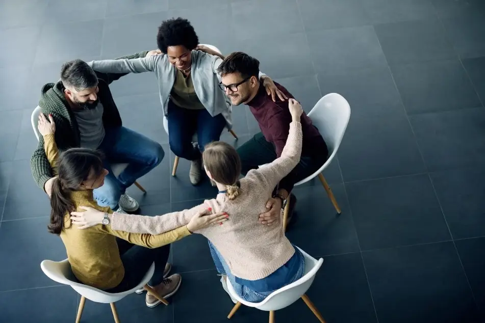 Grupo de personas abrazadas.