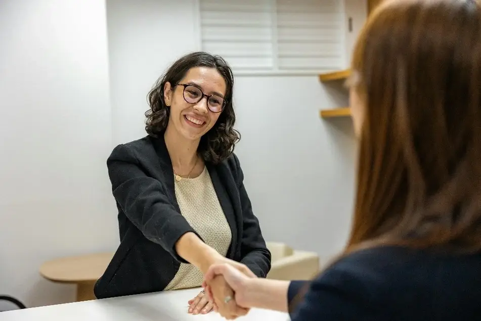 Mulher sorrindo durante uma entrevista de emprego