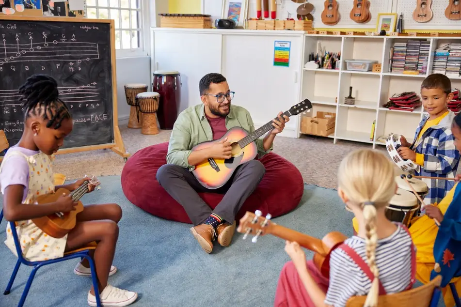 Young instructor leads young children in music class.