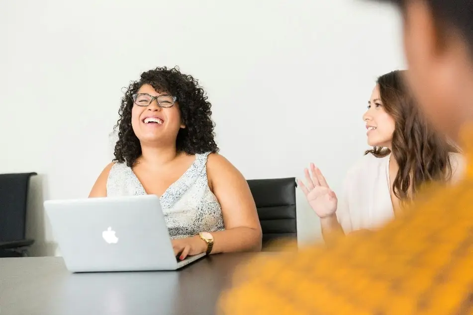 Mujer joven en una reunión de trabajo, sonríendo