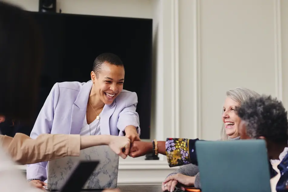 Group of co-workers fist bump at the office