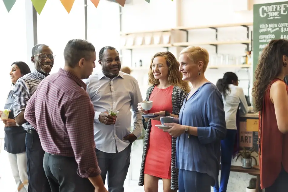 group of colleagues network at a nonprofit event in a city.