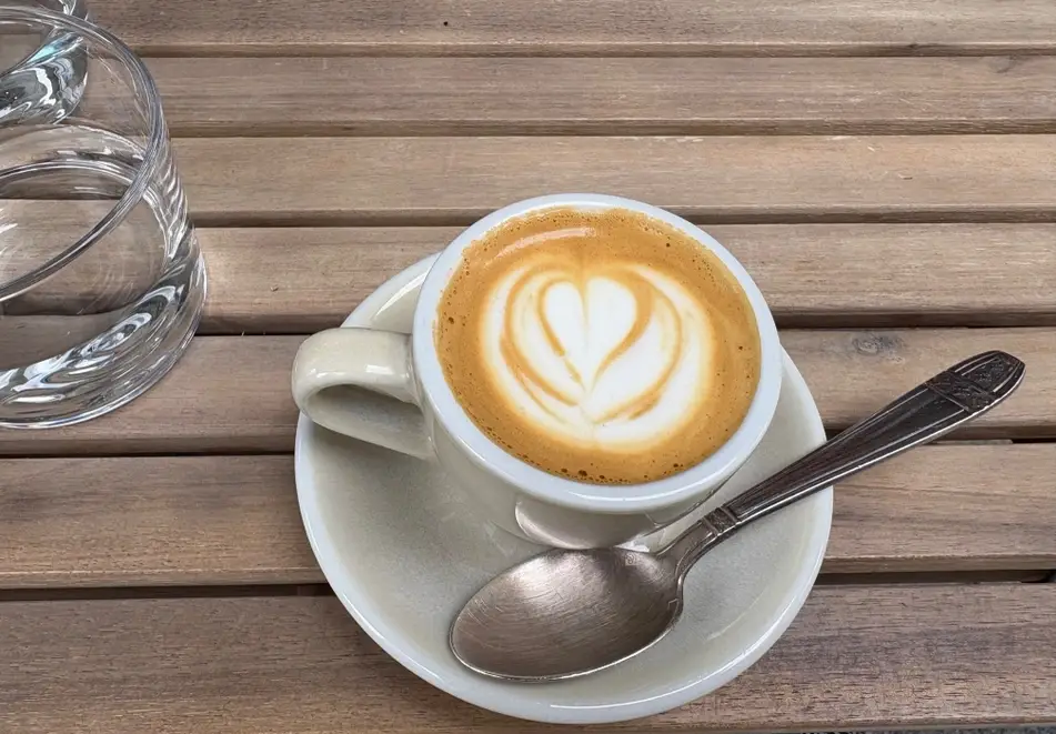 Taza con un café cortado y un vaso de agua