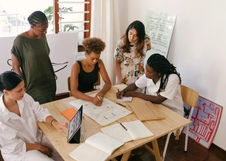 A group of women sitting at a table writing