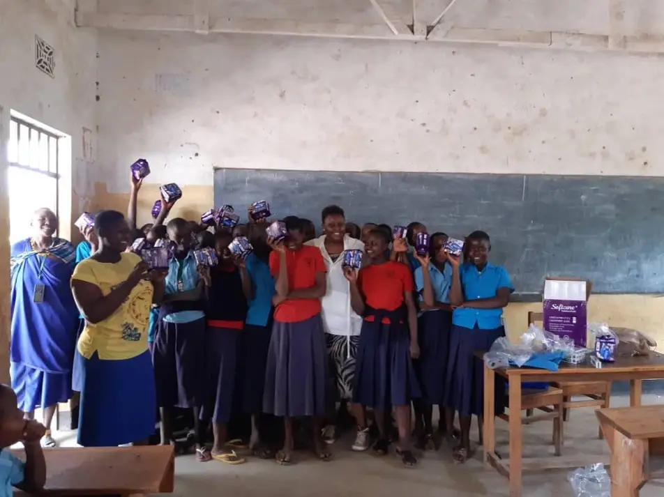 Anne S. from Tanzania distributes menstrual pads to girls in her local community.