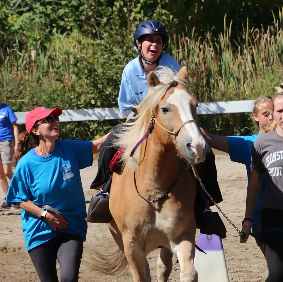 Volunteer with therapeutic riding for people with disabilities