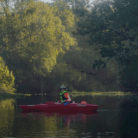 Woman sitting on a red kayak in the beautiful Wekiwa River